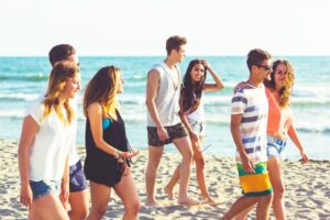 a group of young people walking together on the beach