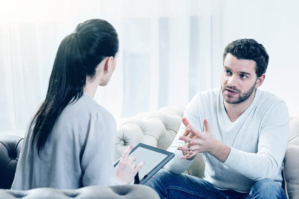 a young male client talking to a counseling staff at a rehab center