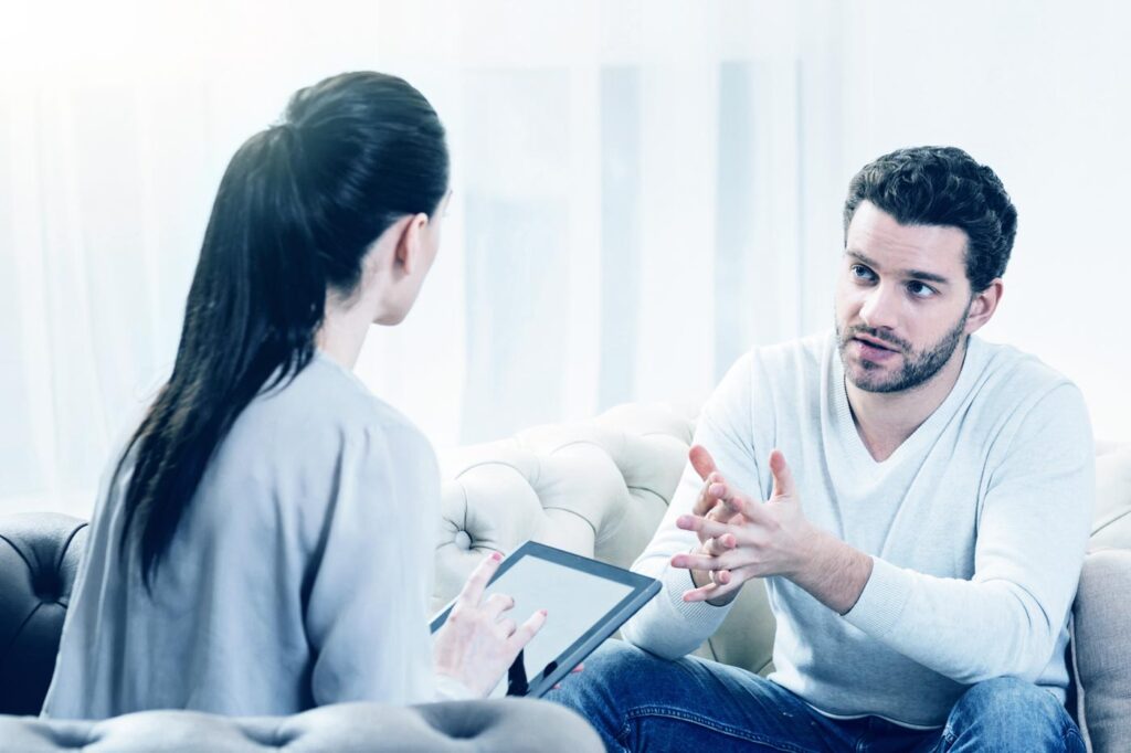 young man consulting a psychologist regarding drug rehab