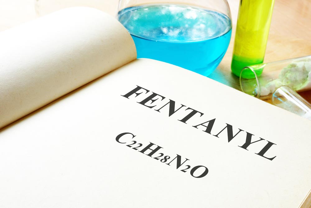 the word fentanyl writtern on a book with test tubes around