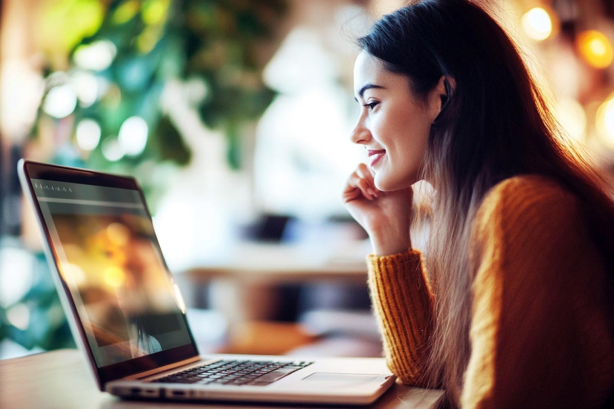 A woman with a laptop receiving online aftercare support for alcohol rehab in Orange County California