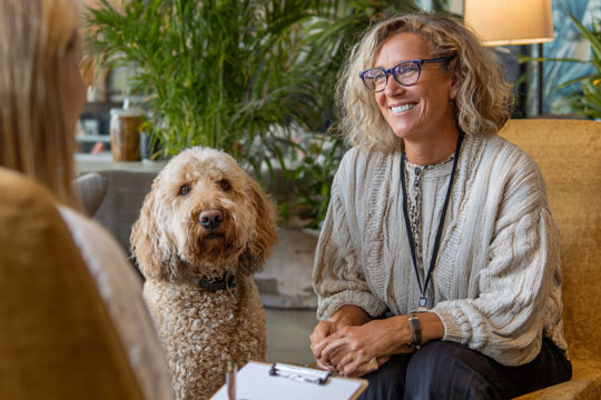 a woman sitting in therapy with her dog