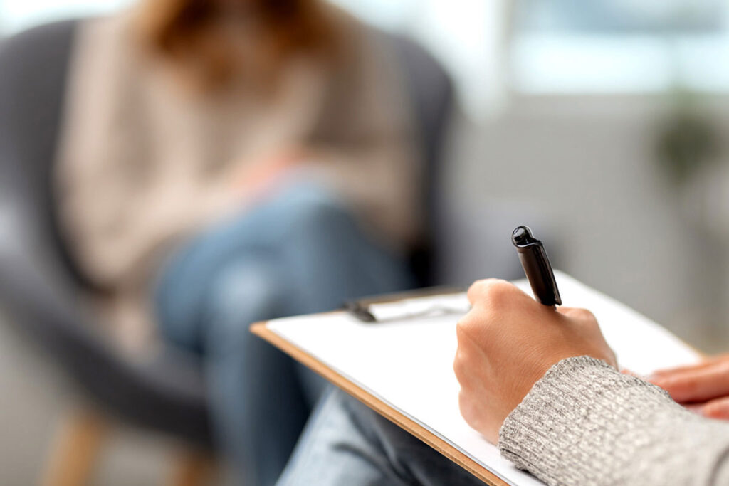 person writing on a clipboard