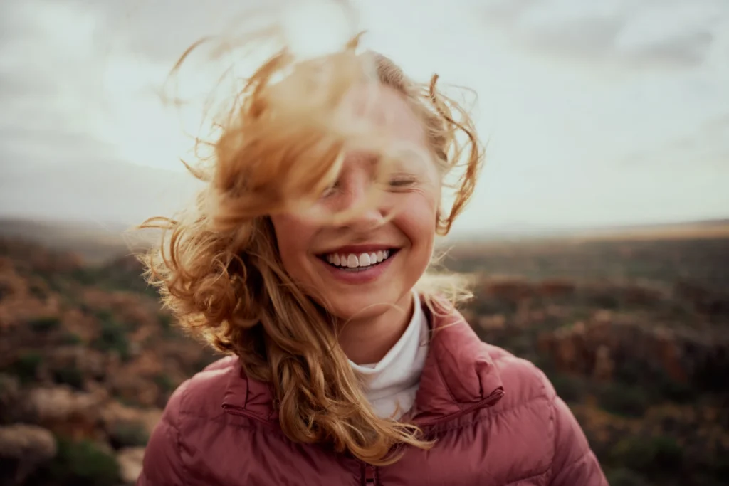 Smiling person in a calm outdoor setting.