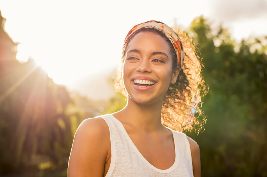 Smiling person in a calm outdoor setting.