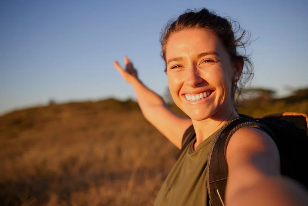 Smiling person in a calm outdoor setting.