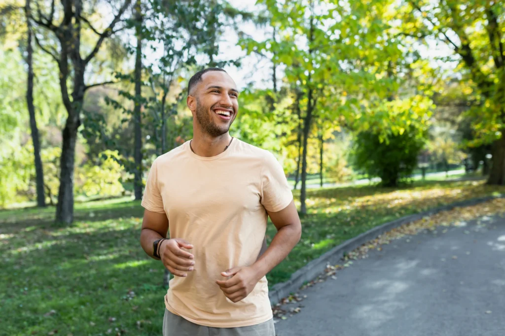 Smiling person in a calm outdoor setting.